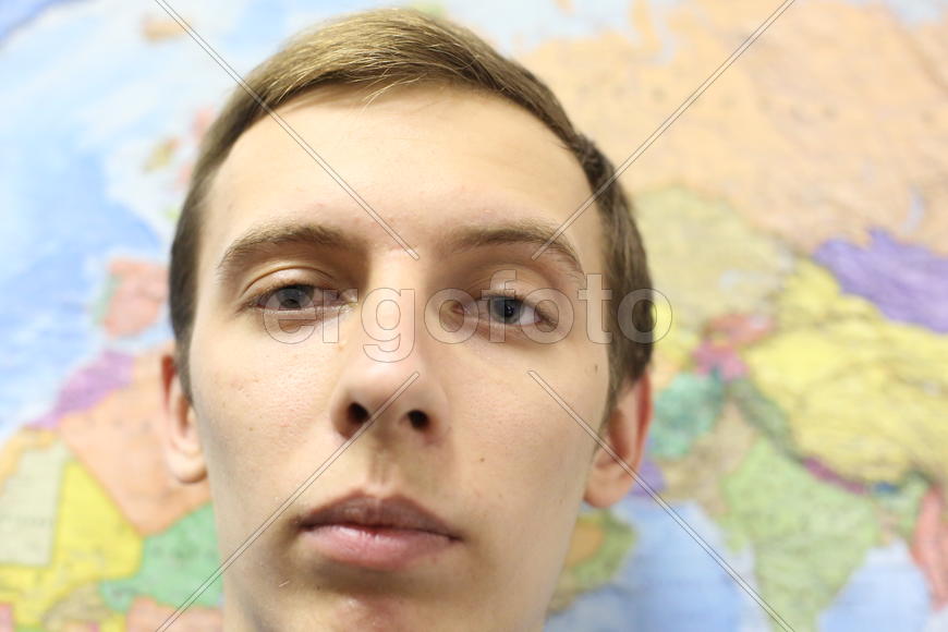 Лицо молодого человека на фоне карты
