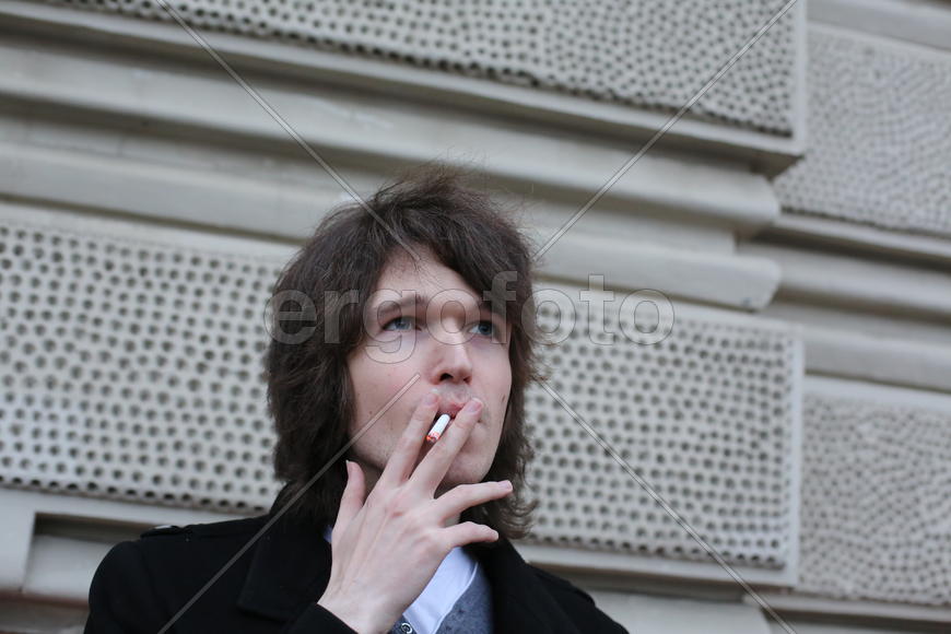 Молодой человек с горящей сигаретой
