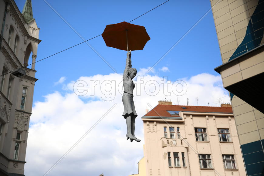 Висящая скульптура женщины под зонтом