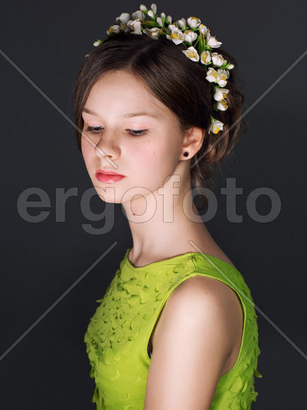 Девушка в зеленом платье с цветочным венком в волосах