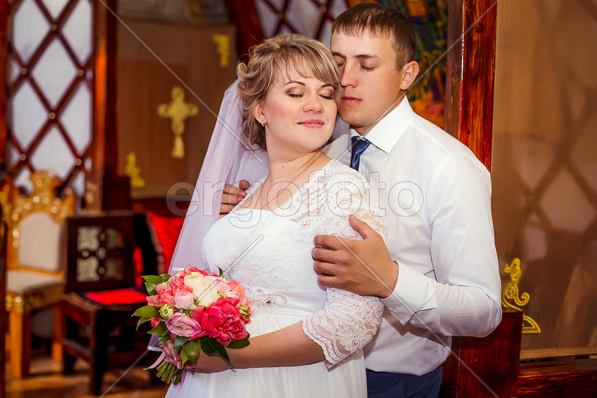 Жених нежно обнимает невесту за плечи