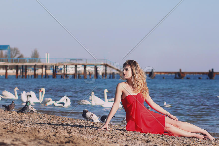 Девушка в красном платье на фоне воды