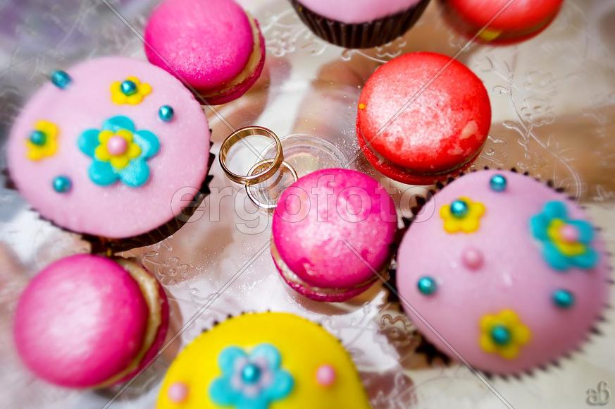 Обручальные кольца на подносе с разноцветными пирожными