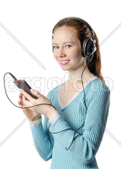 Young smiling girl with headphones with the phone on a white