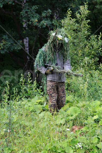 Снайпер в маскировочном костюме гилли в лесу