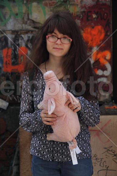 Девушка в очках с игрушкой в руках