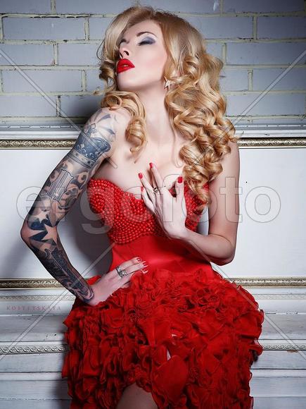 Девушка с татуировкой на руке в платье