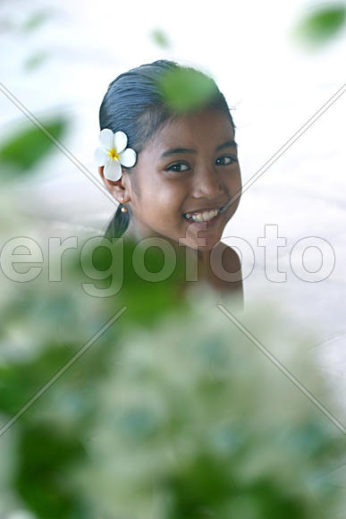 Милая девочка с цветком в волосах