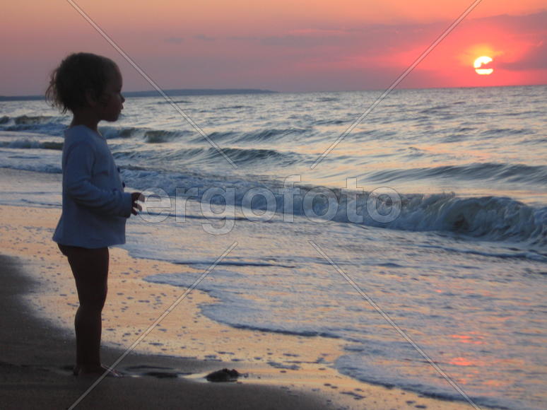 ребенок на море наблюдает закат