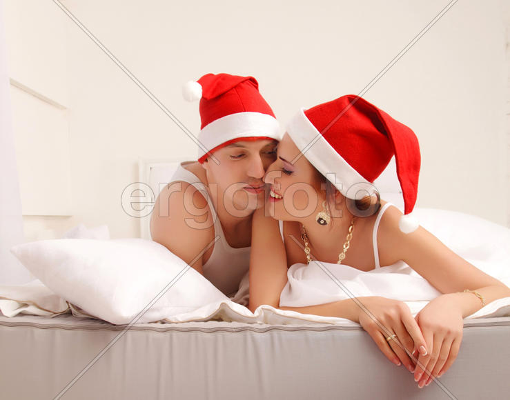 Мужчина и девушка в новогодних колпачках