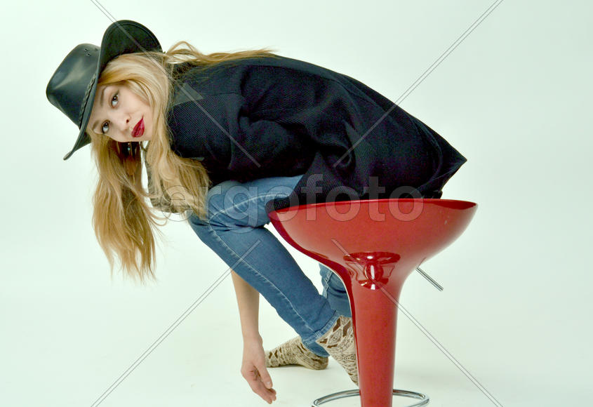 Девушка в шляпе на красном стуле