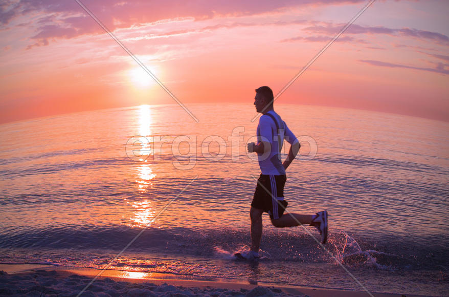 Спортсмен бежит вдоль берега
