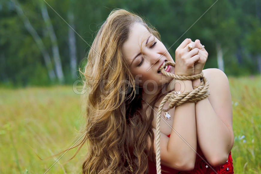 Портрет девушки на поле с завязанными руками