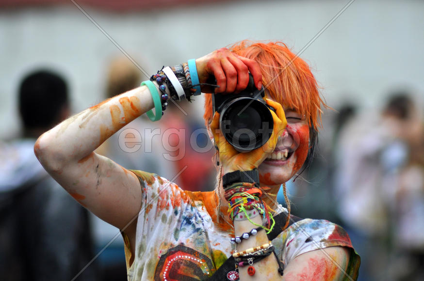 Девушка в красках фотографирует на камеру