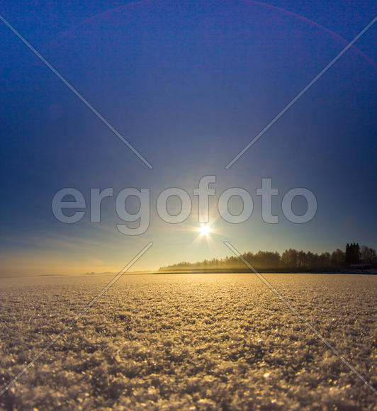 Пейзаж заката над заснеженным полем