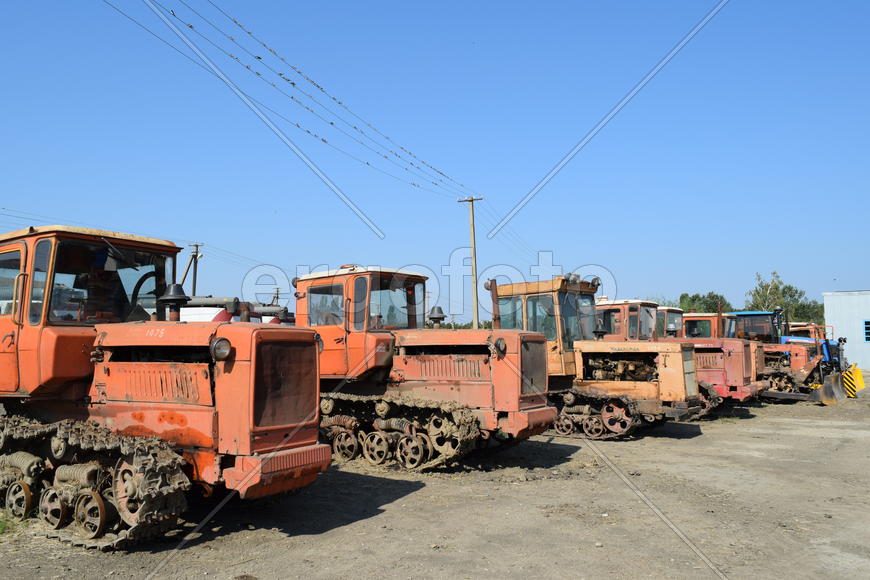 Tractor, standing in a row. Agricultural machinery. Parking of agricultural machinery.