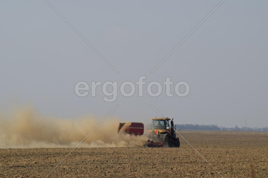 Russia, Temryuk - 19 July 2015: Tractor rides on the field and makes the fertilizer into the soil. C