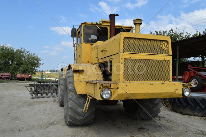 Russia, Temryuk - 15 July 2015: Big yellow tractor. Old Soviet agricultural machinery.