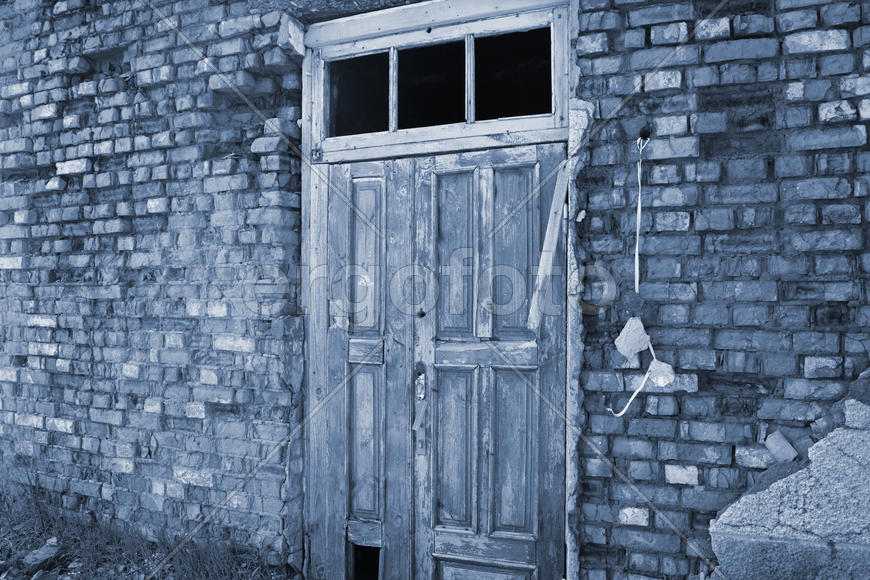 Old door on a dilapidated wall. Abandoned building