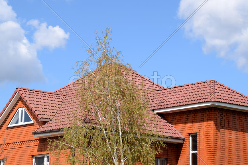 The house with a roof of classic tiles. Roof tiles made of baked clay on the roof.