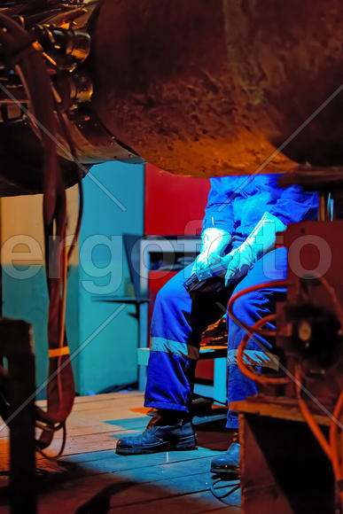 Welder resting during a break at work. Welding of the pipeline. Process of creation of welding conne