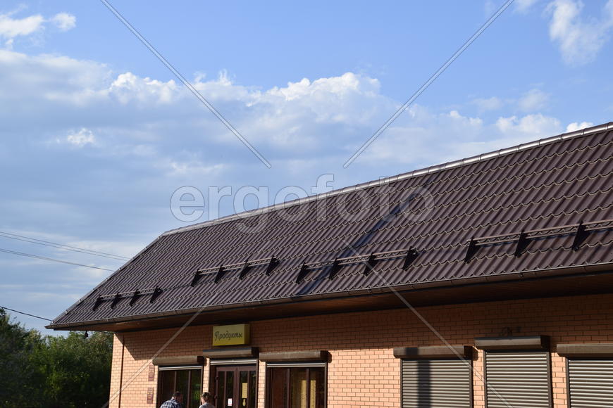 The roof of corrugated sheet on a building. Brown roofing metal sheets on Rented store. 