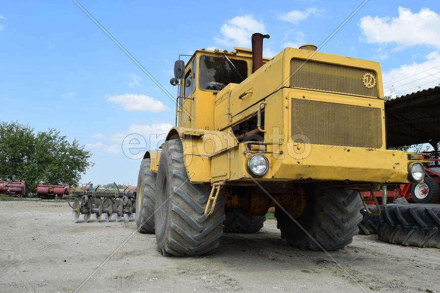 Russia, Temryuk - 15 July 2015: Big yellow tractor. Old Soviet agricultural machinery.