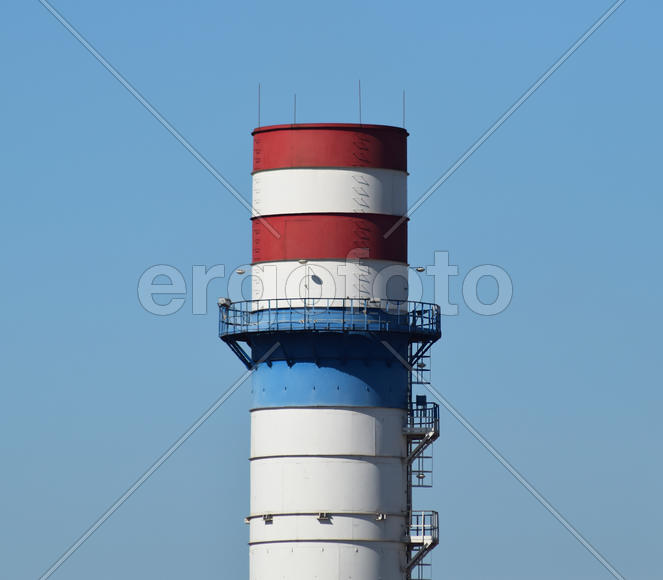 Wide chimney at the plant for the processing of scrap metal. Huge factory old metal refiner. Blue ro