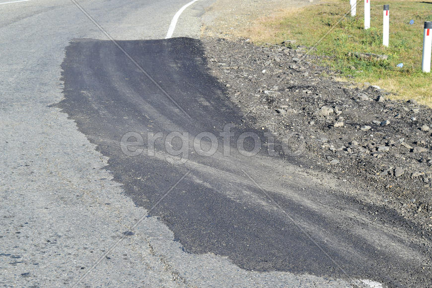 Repair of an asphalt road surfacing. A patch on the asphalt