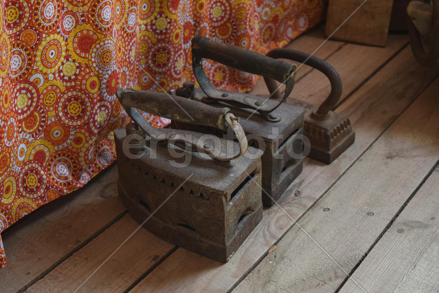 Старинные утюги на деревянном полу 
