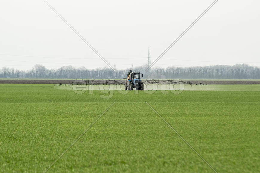 Трактор в поле на распылении гербицидов, Краснодарский край, Россия