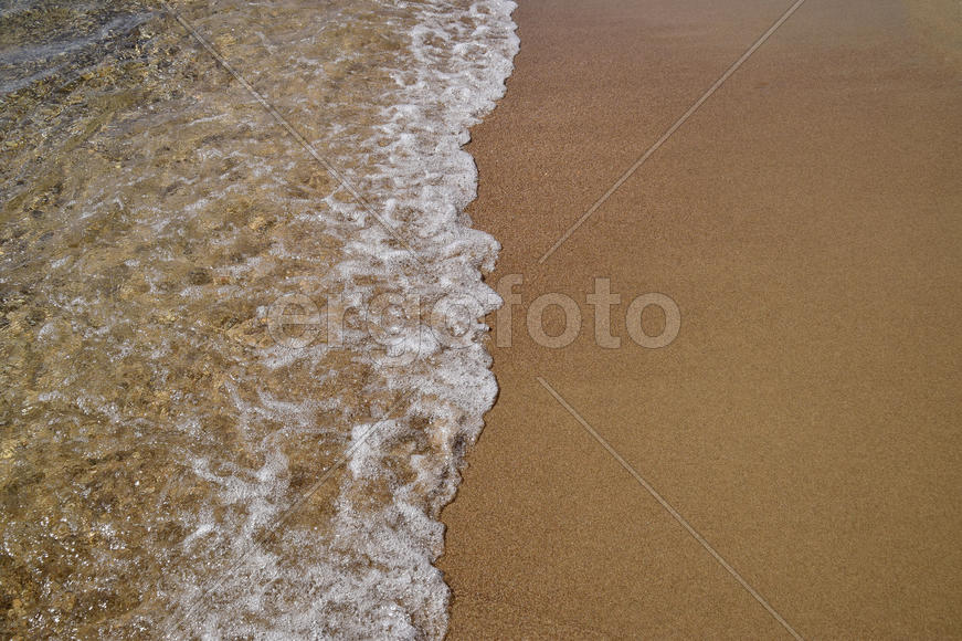 Waves lapping on the sandy shore. Sea beach.