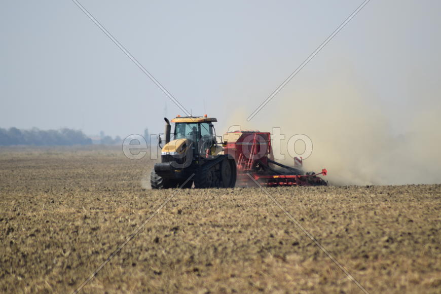 Russia, Temryuk - 19 July 2015: Tractor rides on the field and makes the fertilizer into the soil. C