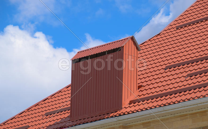 The roof of corrugated sheet red, orange. Roofing of metal profile wavy shape.