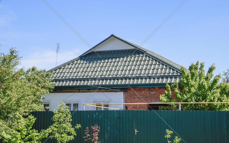 The roof of corrugated green sheet. Roofing of metal profile wavy shape.