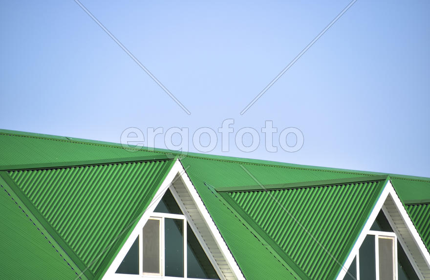 The house with plastic windows and a green roof of corrugated sheet.