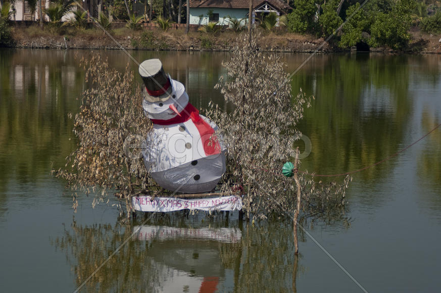 Homemade snowman floats in the middle of a pond in India