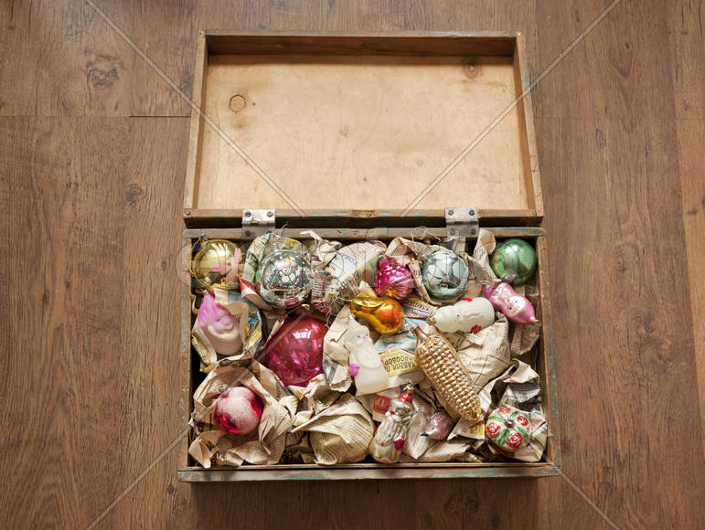 Wooden box of old Christmas toys wrapped in newspaper