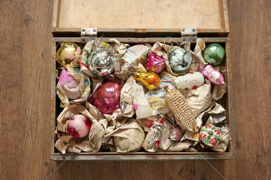 Wooden box of old Christmas toys wrapped in newspaper