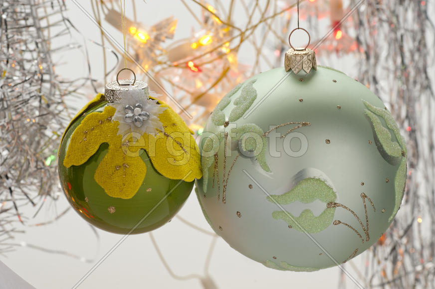 Two Christmas toys in the form of a ball hanging on a branch