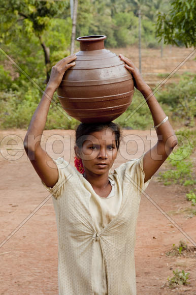 Woman carries water in a jar home