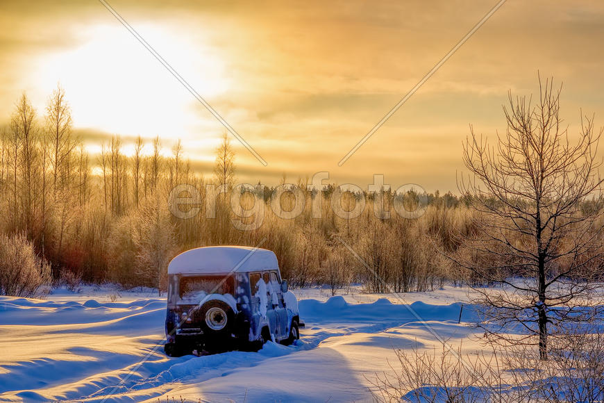 Автомобиль в снегу на рассвете
