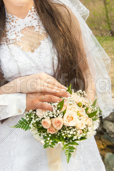Свадебный букет в руках молодоженов 