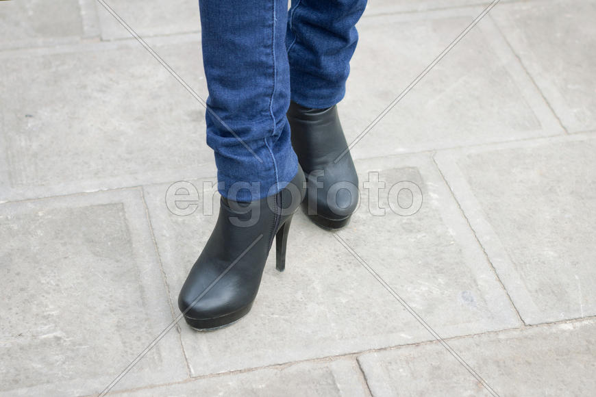 Girl's leg with black boots on a high heel. Street style