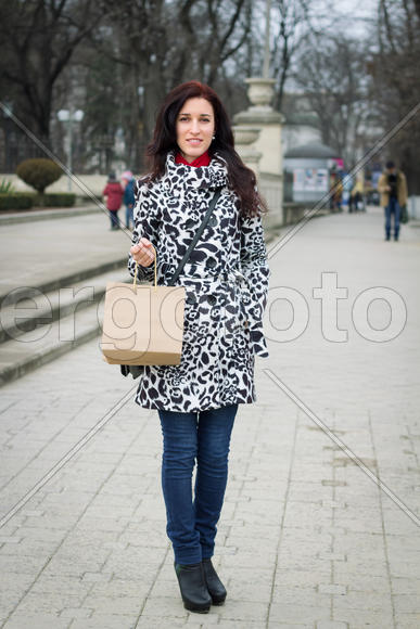 Young beauty woman in casual clothes with shopping bag walking through street