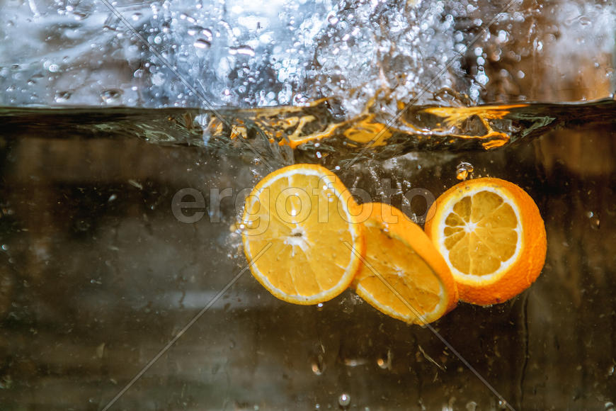 Ломтики апельсина падающие в воду 