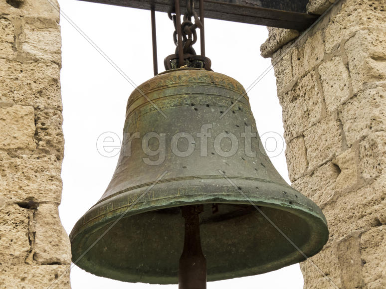 The ancient bell hangs on an ancient wall and never calls