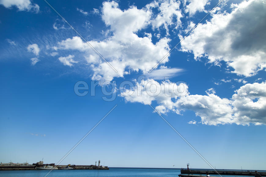 City bay with the ships in it under the blue sky and a bright sun