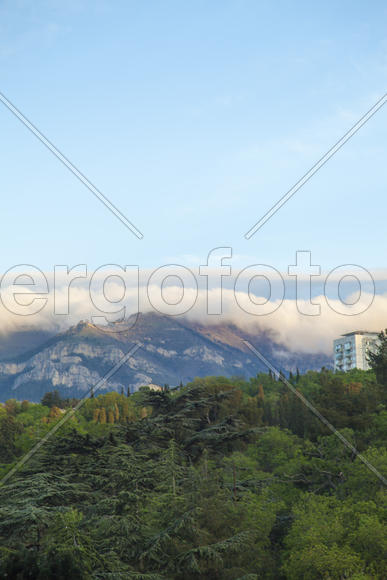 Mountains by the sea at sunrise in beams of the soft sun