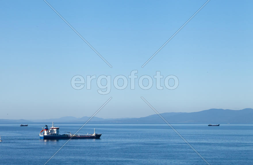 Seascape with ships and mountains on the horizon a bright sunny day